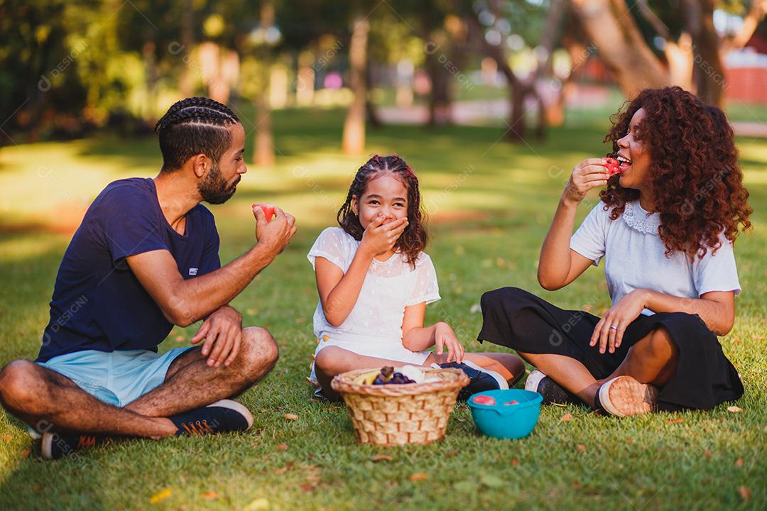 Família feliz fazendo piquenique no parque