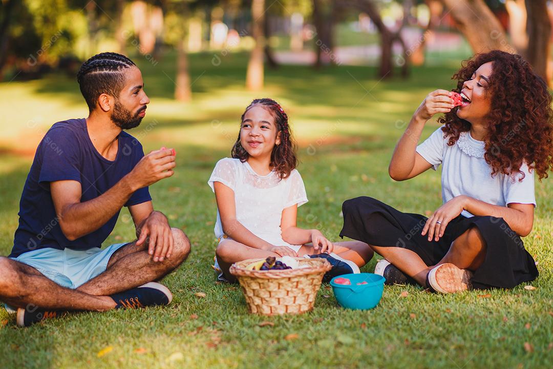 Família feliz fazendo piquenique no parque