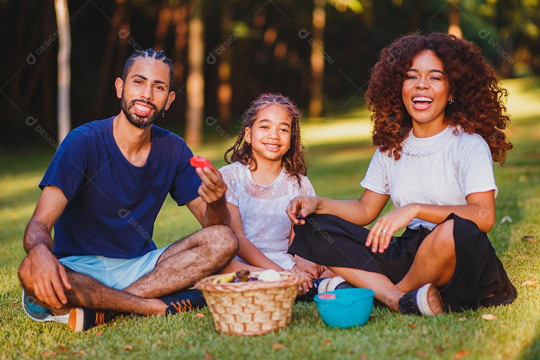 Família feliz fazendo piquenique no parque