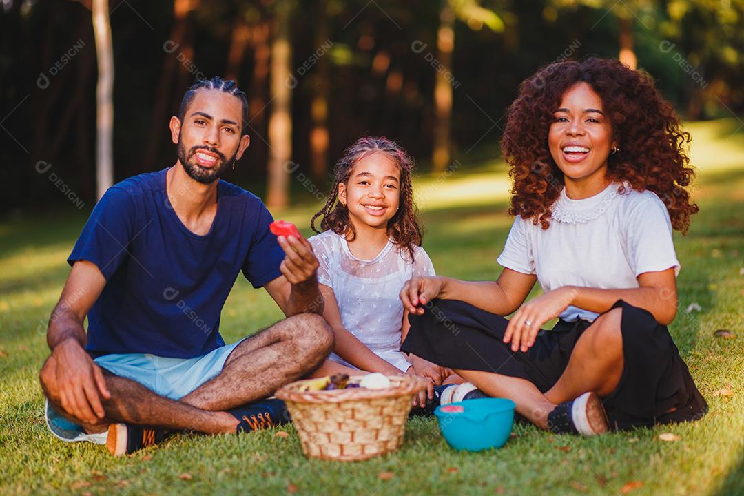 Família feliz fazendo piquenique no parque