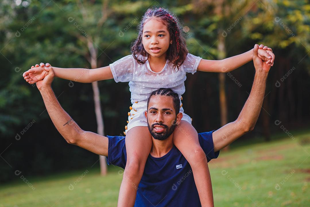 Afro pai e filha no parque
