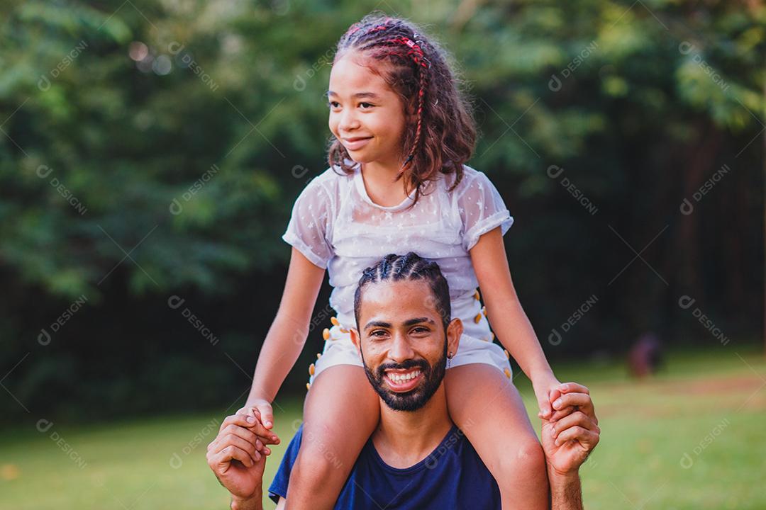 Afro pai e filha no parque