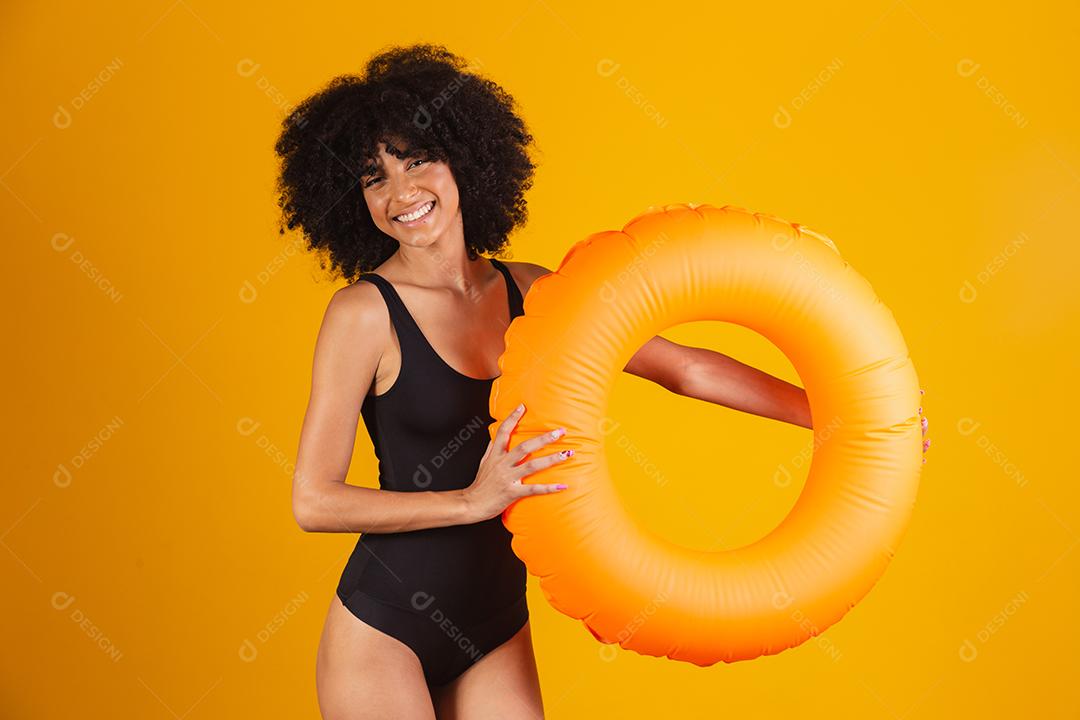 Linda mulher afro segurando lifebuoy em fundo amarelo. mulher com boia flutuante