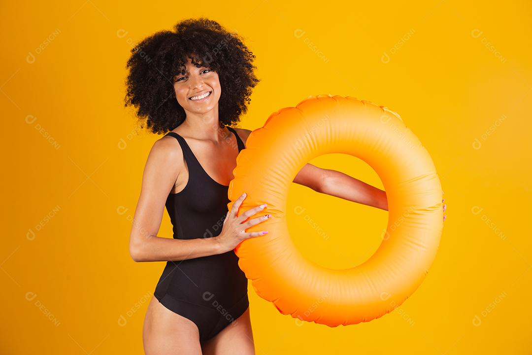 Linda mulher afro segurando lifebuoy em fundo amarelo. mulher com boia flutuante