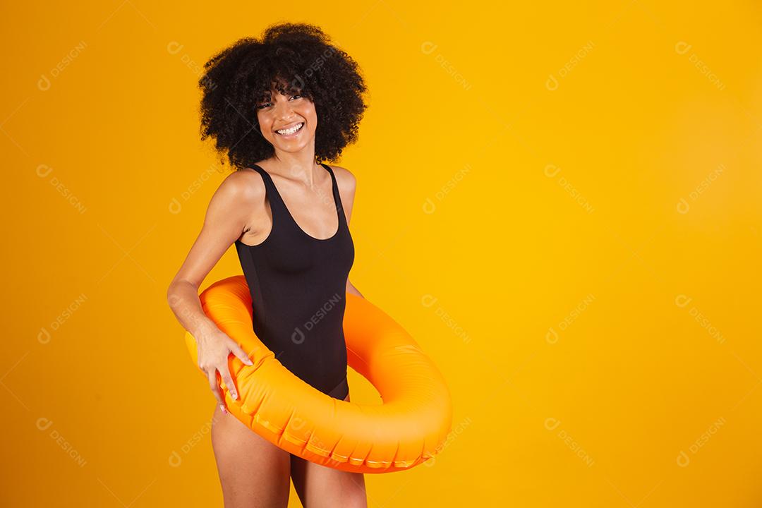Linda mulher afro segurando lifebuoy em fundo amarelo. mulher com boia flutuante