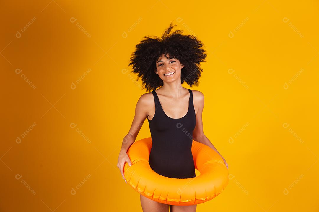 Linda mulher afro segurando lifebuoy em fundo amarelo. mulher com boia flutuante