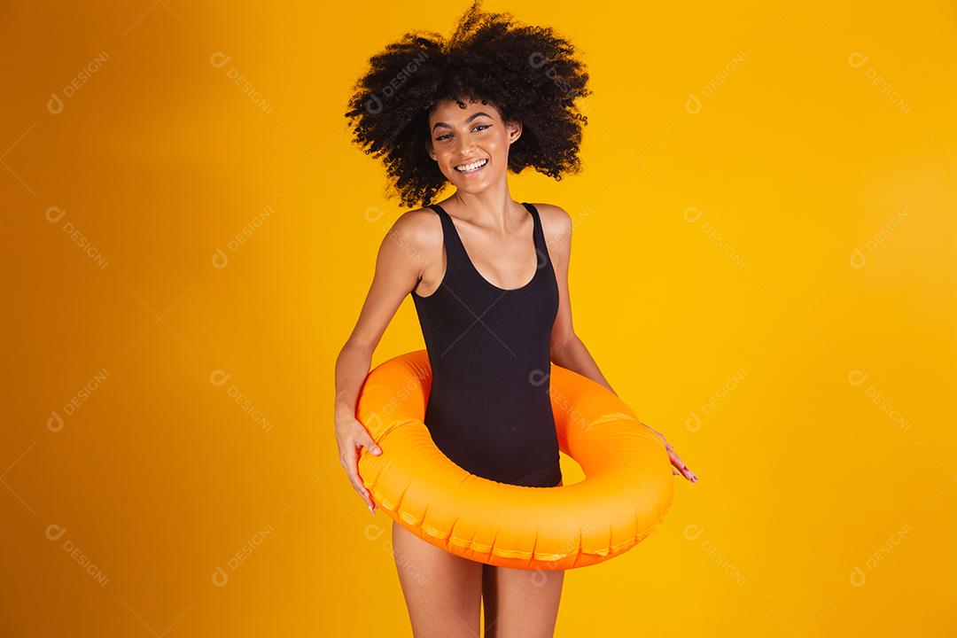 Linda mulher afro segurando lifebuoy em fundo amarelo. mulher com boia flutuante