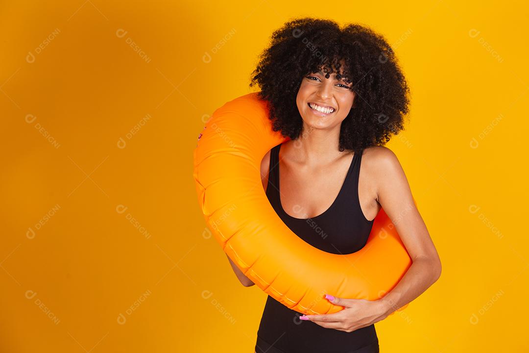 mulher afro com uma bóia flutuante em fundo amarelo