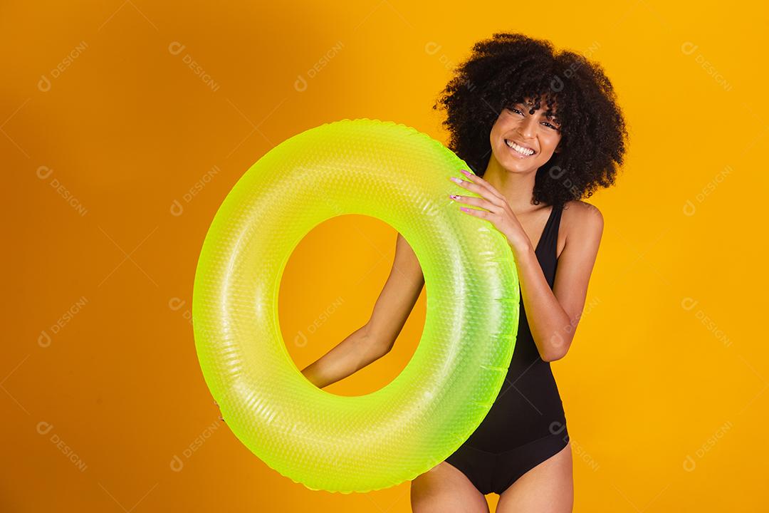 mulher afro com uma bóia flutuante em fundo amarelo