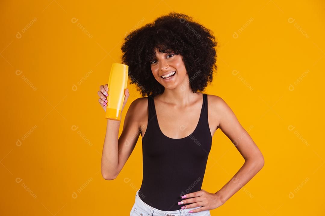 jovem afro segurando nas mãos um pacote de creme de cabelo