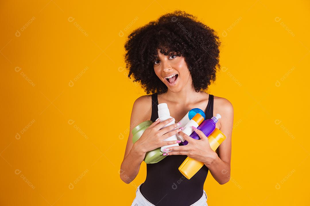 jovem afro segurando nas mãos um pacote de creme de cabelo