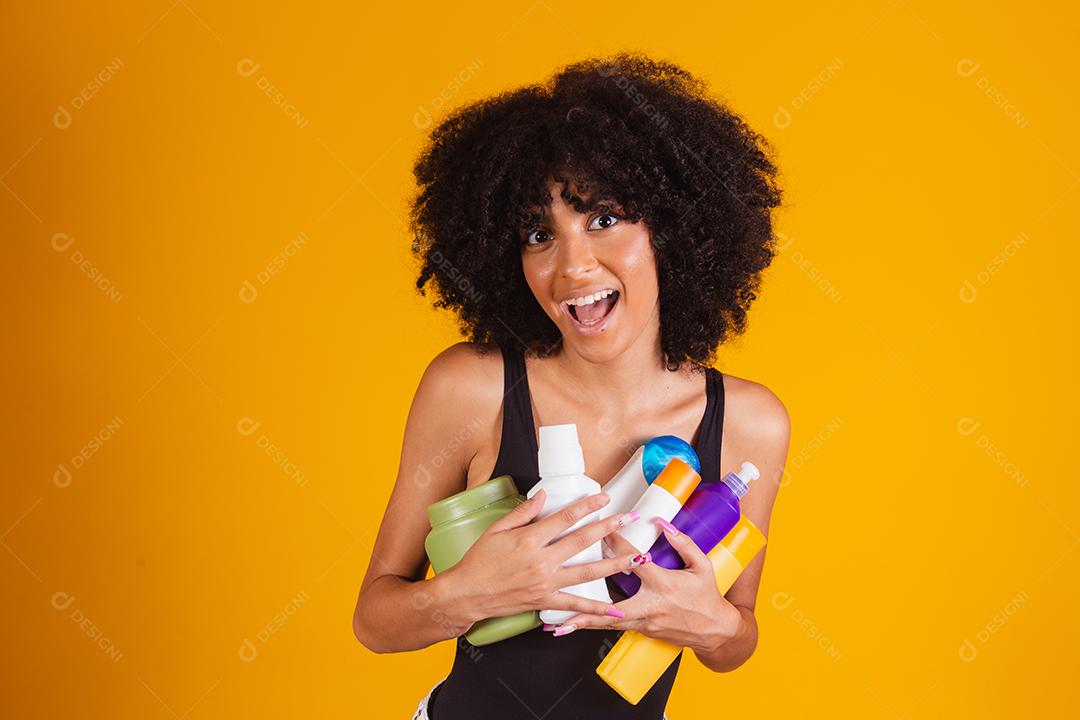 jovem afro segurando nas mãos um pacote de creme de cabelo
