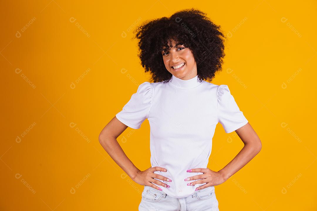 Mulher afro com lindo cabelo preto sorrindo em fundo amarelo