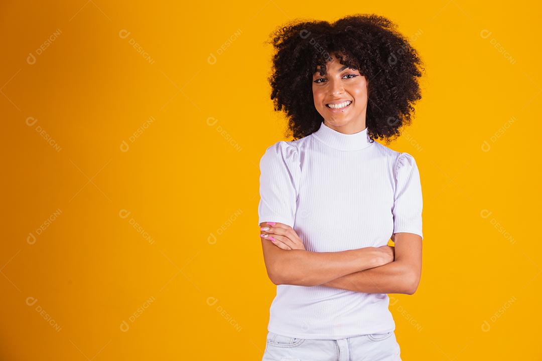 Mulher afro com lindo cabelo preto sorrindo em fundo amarelo