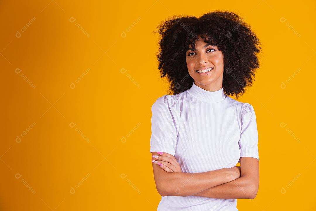 Mulher afro com lindo cabelo preto sorrindo em fundo amarelo