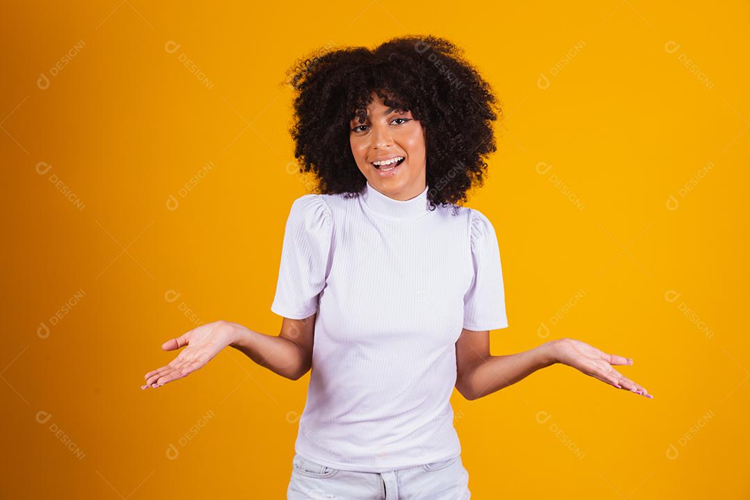 Mulher afro com lindo cabelo preto sorrindo em fundo amarelo