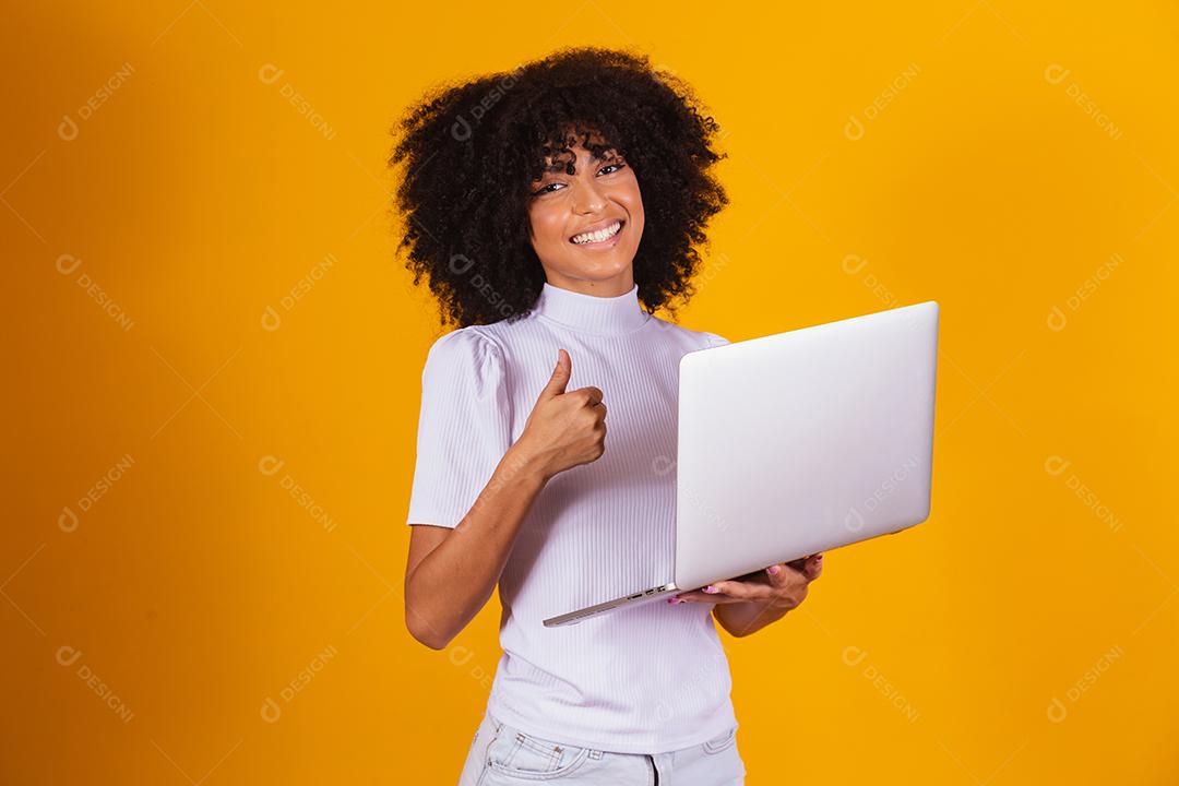mulher afro com o polegar para cima usando um computador