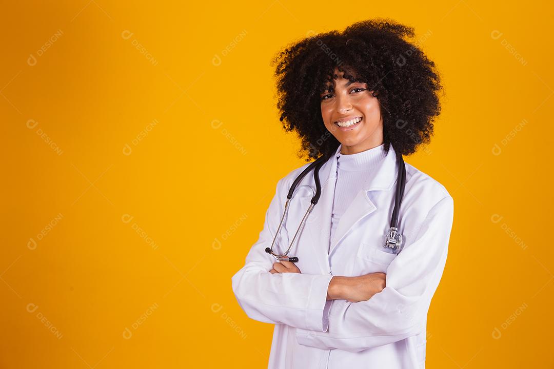 médica com braços cruzados, olhando para a câmera