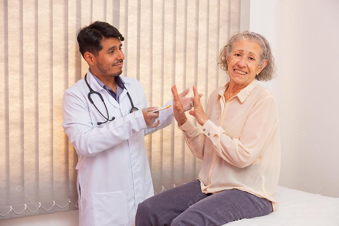 Mulher idosa com raiva por ter que tomar remédio. Médico tentando convencer a idosa a tomar remédio