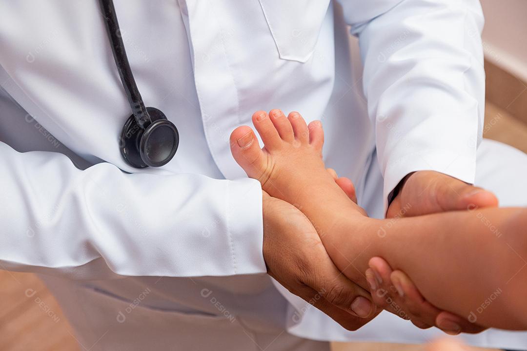 médico examinando os pés das crianças no hospital. Cirurgião, traumatologista ou ortopedista palpando a perna e o pé da menina