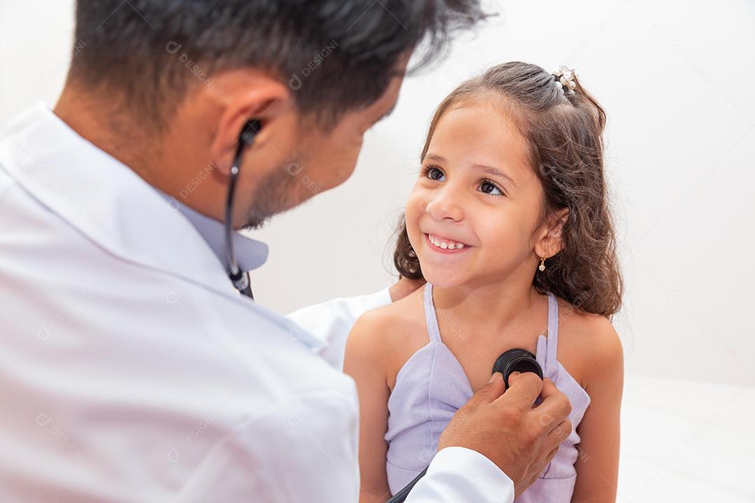 médico atencioso examinando uma garota Doutor examinando pulmão e coração de garotinha