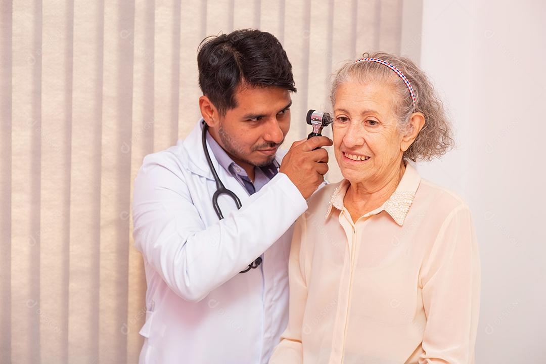 Médico examinando orelha de mulher idosa com otoscópio na clínica