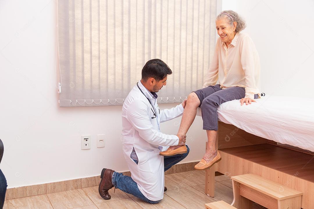 médico fisioterapeuta examinando, massageando e tratando o joelho e a perna do paciente idoso no hospital de enfermagem da clínica médica ortopédica.