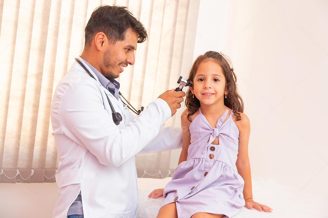 Médico examina a orelha com otoscópio em uma sala de pediatra. Equipamento médico