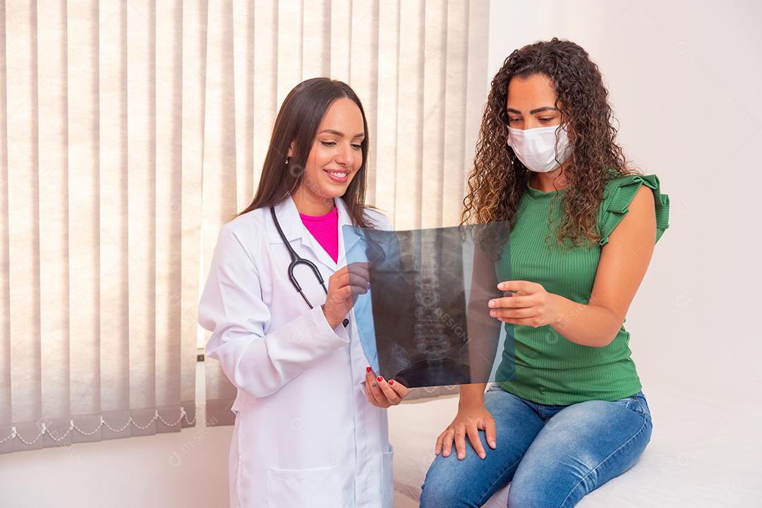 enfermeira mostrando paciente seu exame de raio-x da coluna.