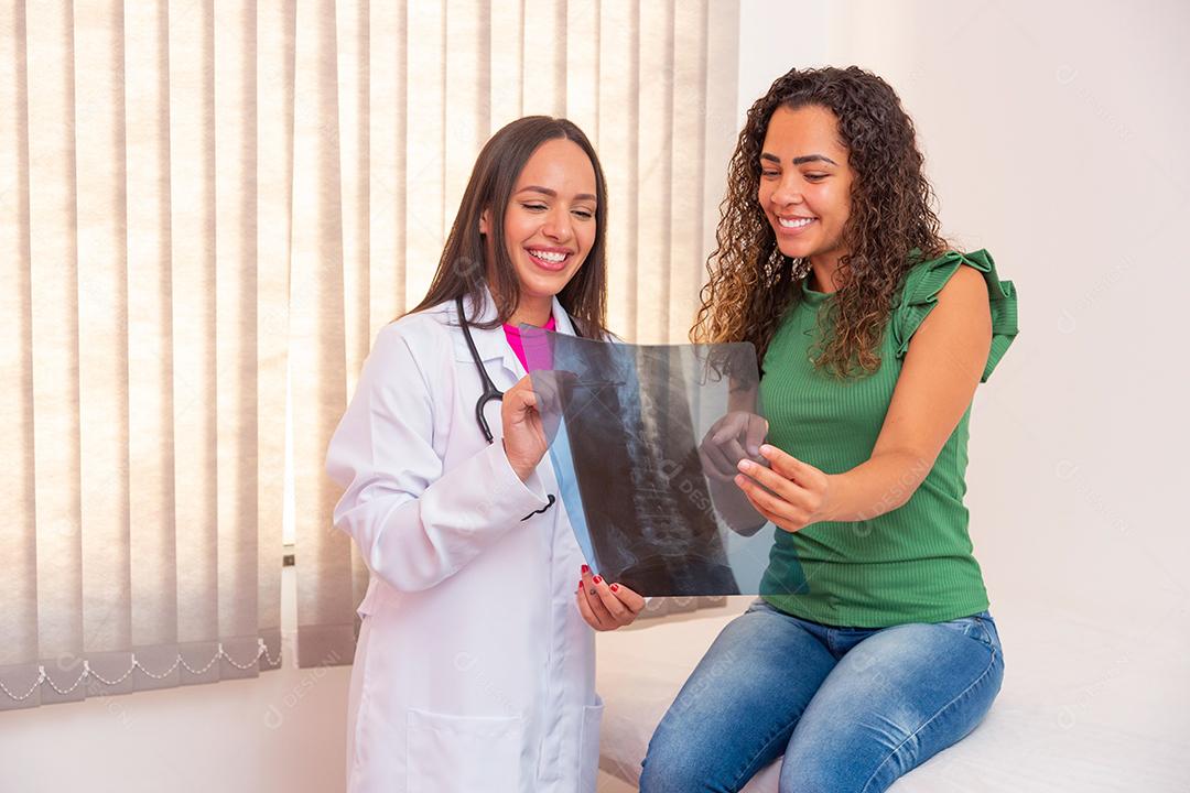 enfermeira mostrando paciente seu exame de raio-x da coluna.