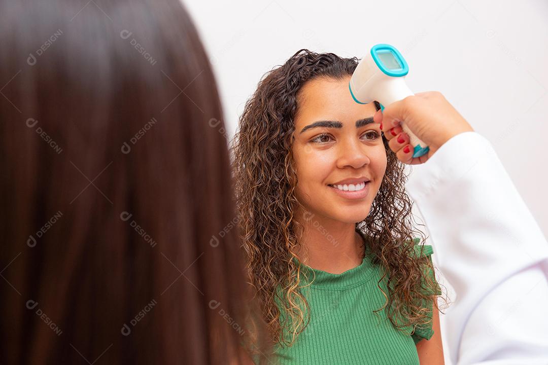 Enfermeira medindo febre com termômetro digital