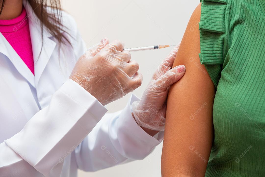 Enfermeira aplicando a vacina contra covid 19 e a nova variante omicron