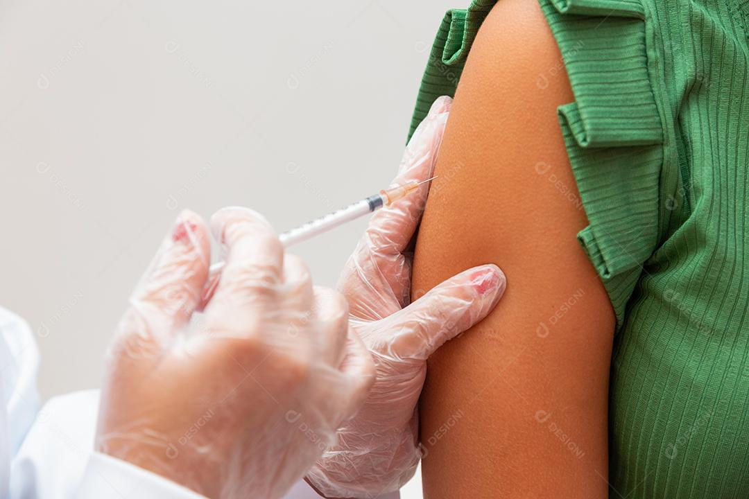 Enfermeira aplicando a vacina contra covid 19 e a nova variante omicron