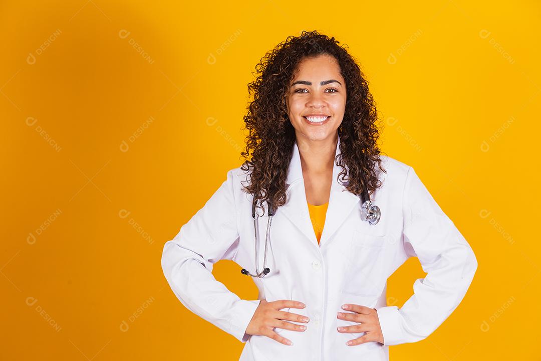 Mulher médica brasileira sorridente em um jaleco branco.
