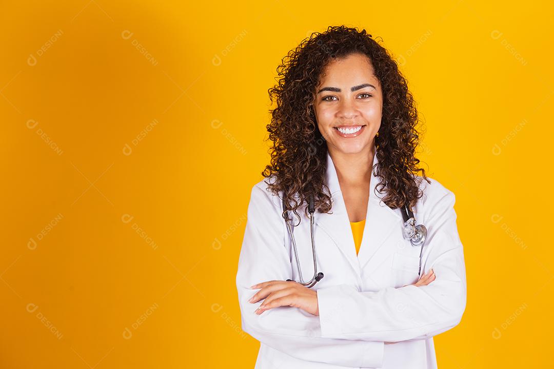 Mulher médica brasileira sorridente em um jaleco branco.