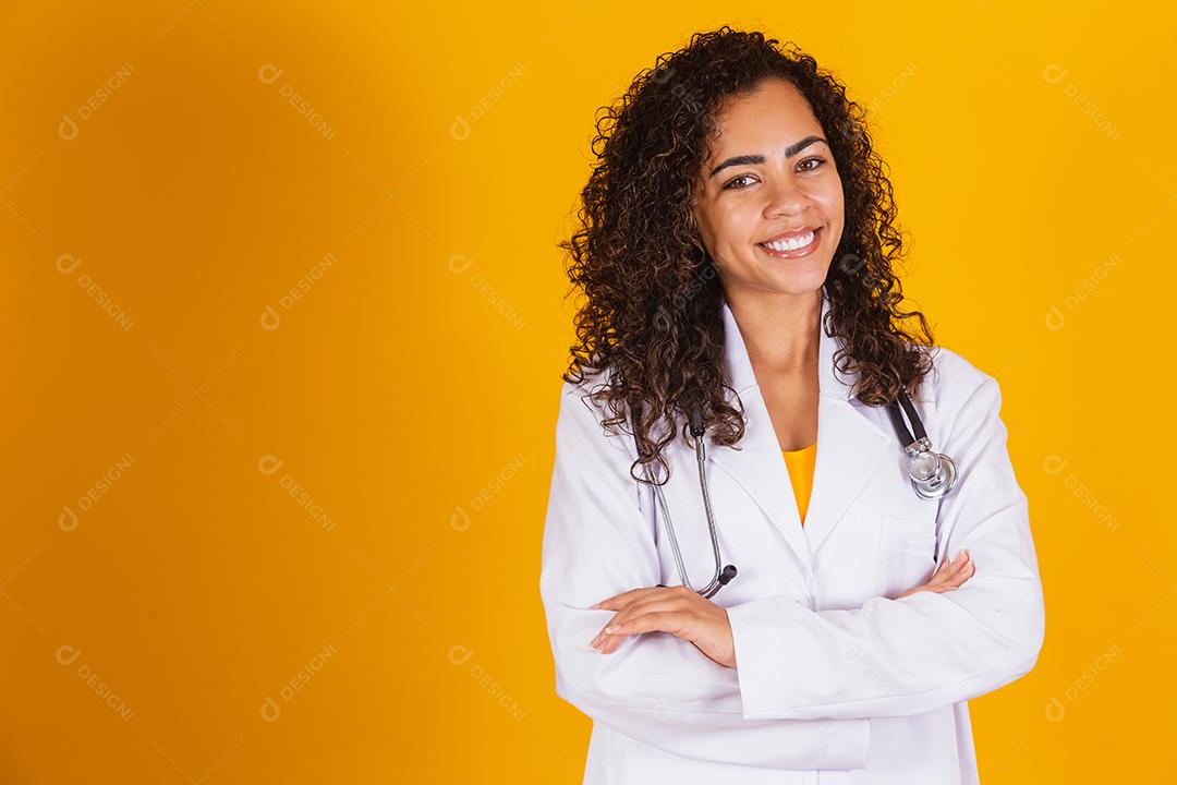 Mulher médica brasileira sorridente em um jaleco branco.