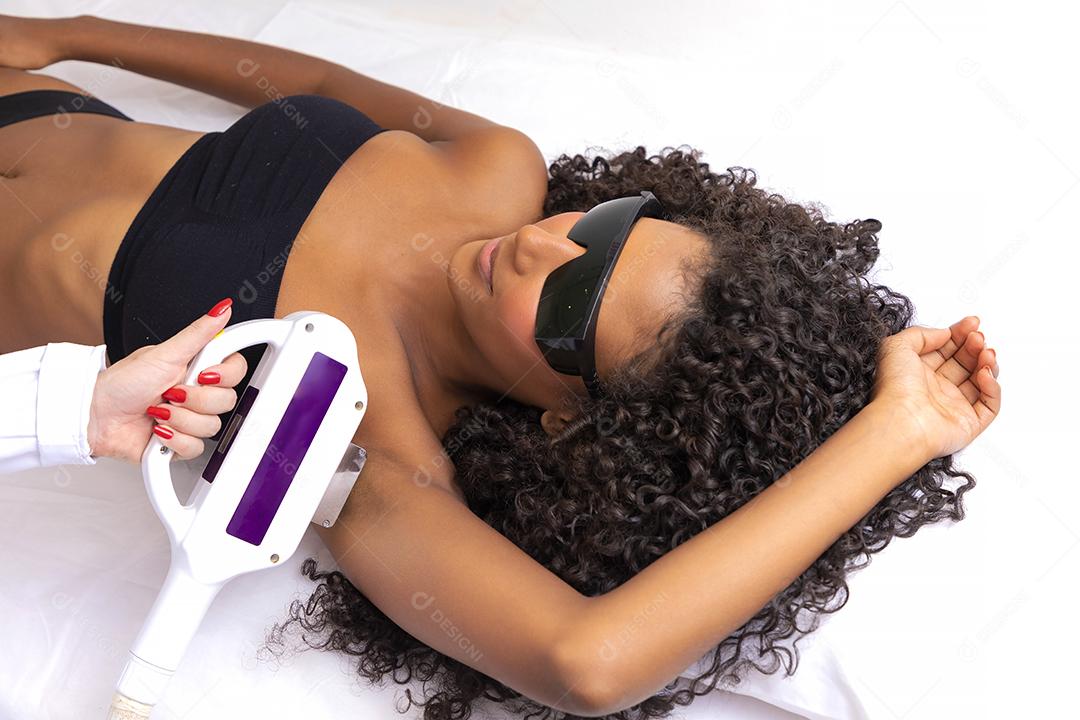 Mulher negra brasileira realizando depilação a laser em sua axila