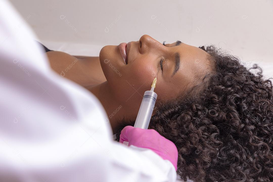 Mulher aplicando ozônio no rosto para tratamento cosmético.