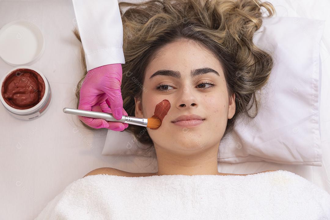 mulher deitada em maca em clinica de estética