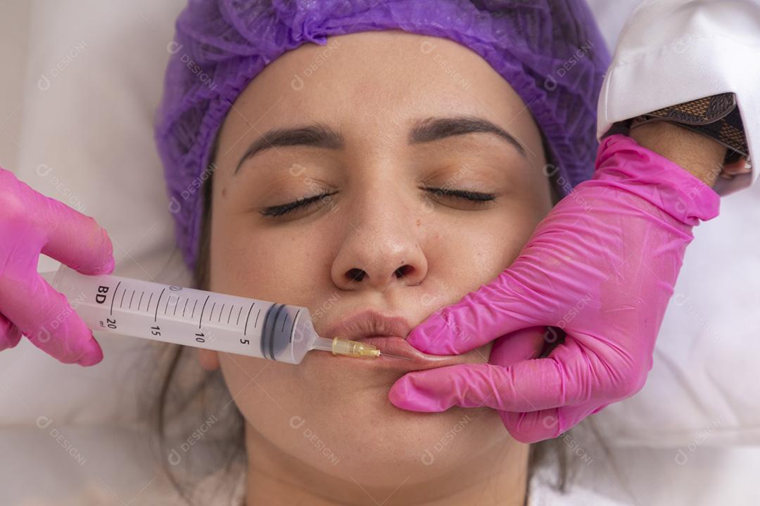Aumento labial. Boca de mulher jovem e bonita recebendo Hyalur