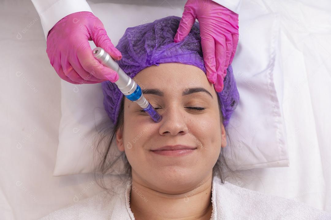 Jovem deitada na mesa do cosmetologista durante o rejuvenescimento p