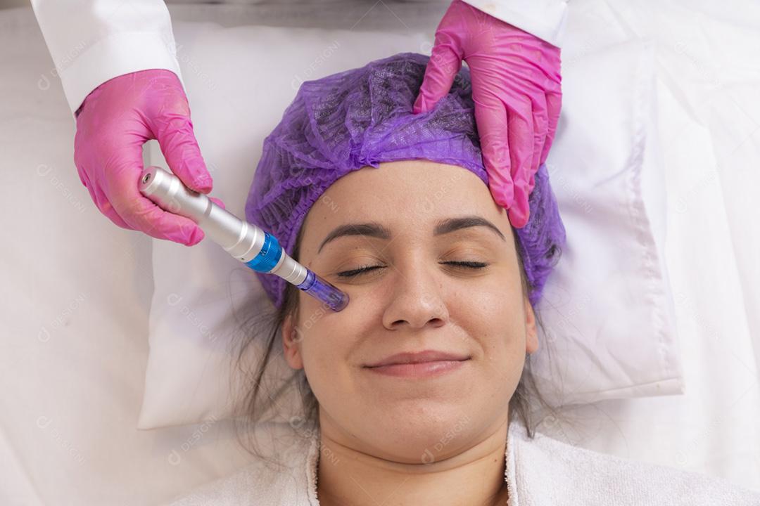 Jovem deitada na mesa do cosmetologista durante o rejuvenescimento p