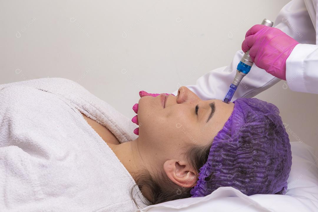 Jovem deitada na mesa do cosmetologista durante o rejuvenescimento p