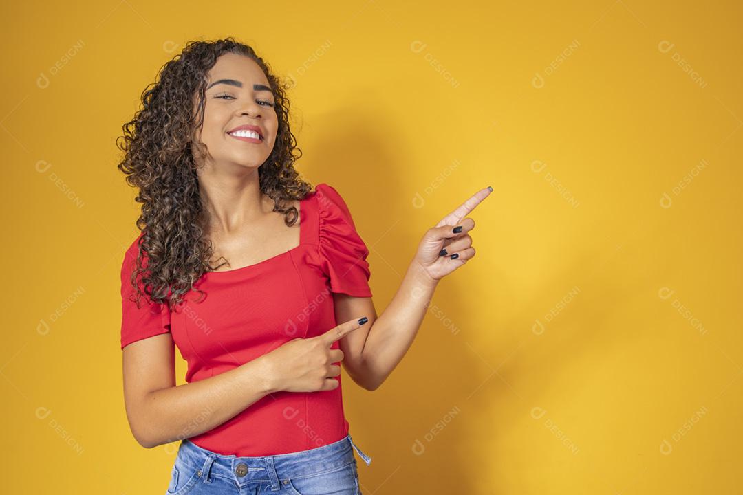 Mulher afro apontando em fundo amarelo com espaço para o texto