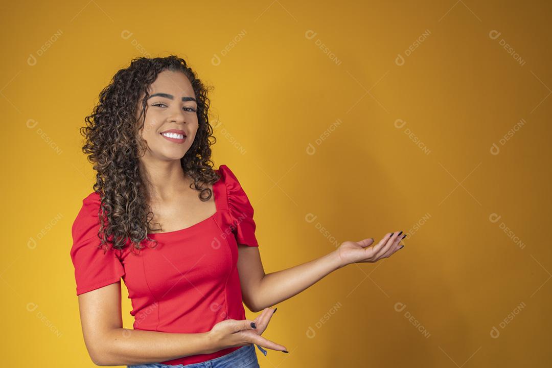 Mulher afro apontando em fundo amarelo com espaço para o texto