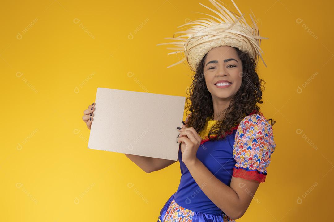 Linda mulher vestida com roupa de festa junina segurando um s em branco