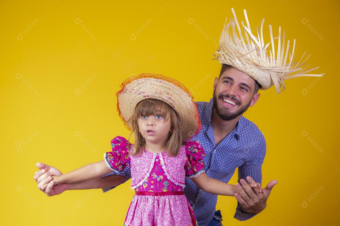 Pai e filha vestidos com roupas de festa junina. Papai jovem um
