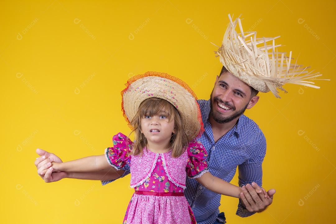 Pai e filha vestidos com roupas de festa junina. Papai jovem um