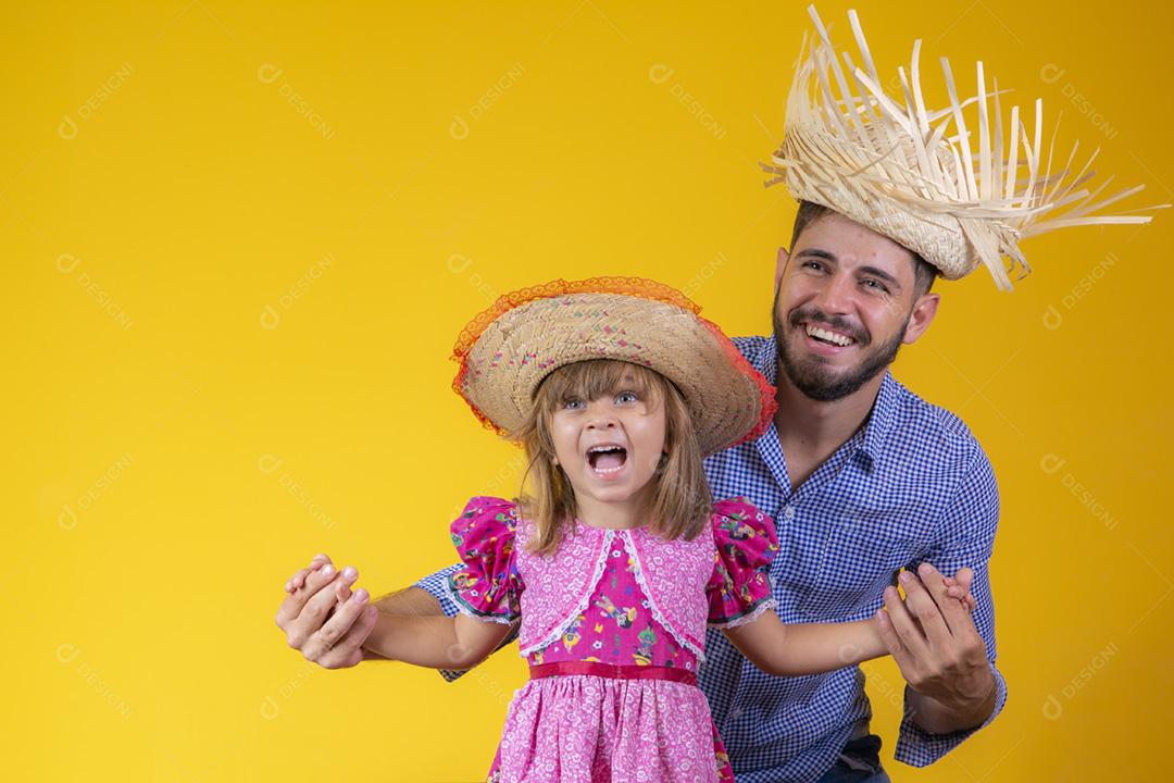 Pai e filha vestidos com roupas de festa junina. Papai jovem um