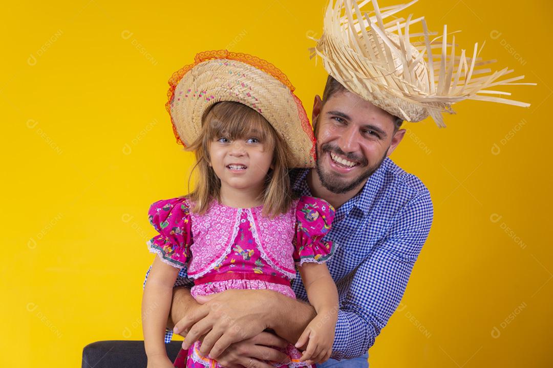 Pai e filha vestidos com roupas de festa junina. Papai jovem um